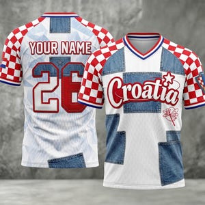 May include: White and blue soccer jersey with red and white checkered sleeves. The jersey features denim-style patches, the word "Croatia" in red, and the number "26" on the back. The text "YOUR NAME" is above the number.