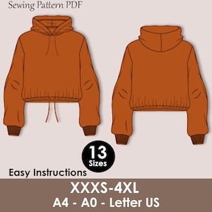 Op de afbeelding: Illustratie van een PDF-naaipatroon voor een cropped hoodie in roestoranje, met voor- en achteraanzicht. Het patroon bevat 13 maten, van XXXS tot 4XL, en is ontworpen voor A4, A0 en Letter US papierformaten. De tekst "Easy Instructions" is ook zichtbaar.