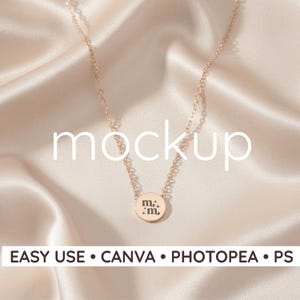 Puede incluir: Collar de oro rosa con una cadena delicada y un colgante circular. El colgante está grabado con las letras "m." y "m." sobre un fondo satinado. La palabra "mockup" se muestra en blanco. También se muestra el texto "EASY USE • CANVA • PHOTOSHOP • PS".