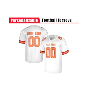 Puede incluir: Dos camisetas de fútbol blancas con números y detalles en naranja. Una camiseta muestra "YOUR NAME" y el número "00" en la espalda. La otra camiseta muestra "YOUR TEAM" y el número "00". El texto "Personalizable Football Jerseys" se muestra arriba.