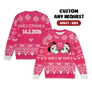 Könnte beinhalten: Rosa Weihnachts-Sweater mit weißen Akzenten und einem Mickey Mouse-Thema. Der Pullover zeigt den Text "NAME A ♡ NAME B" und das Datum "14.2.2026". Das Design umfasst Herzen, Schneeflocken und Mickey Mouse-Silhouetten. Der Text "CUSTOM ANY REQUEST ADULT - KIDS" ist ebenfalls sichtbar.