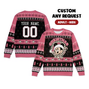Könnte beinhalten: Rosa-schwarzer Weihnachtspullover mit Mickey Mouse-Design. Der Pullover zeigt den Text "Christmas Vibes" und "Your Name" mit der Nummer "00". Das Design umfasst Schneeflocken, Weihnachtsbäume und Mickey Mouse-Gesichter.