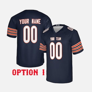 K&ouml;nnte beinhalten: Marineblaues Football-Trikot mit wei&szlig;en Zahlen und Schriftz&uuml;gen. Das Trikot hat orange und wei&szlig;e Streifen auf den &Auml;rmeln. Die Texte "YOUR NAME" und "YOUR TEAM" sind sichtbar. Die Nummer "00" wird prominent angezeigt. Der Text "OPTION 1" ist ebenfalls sichtbar.