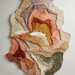 May include: An abstract rug in a range of earthy tones, including beige, pink, orange, and green. The rug has a layered design and an irregular shape, creating a unique, artistic appearance. The text "Dynmo Design" is visible. The rug's texture is visible.