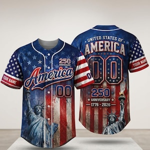 Könnte beinhalten: Ein Baseballtrikot mit Knopfleiste und einem rot-weiß-blauen Flaggenmuster. Die Vorderseite zeigt die Freiheitsstatue, den Schriftzug America, 250 Anniversary und die Nummer 00. Die Rückseite zeigt United States of America, 00 und 1776-2026.