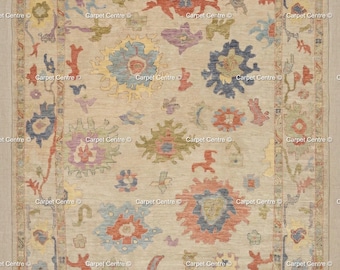 May include: A beige area rug with a floral pattern in shades of blue, red, yellow, and purple. The rug has a border with repeating floral and geometric designs. The text "Carpet Centre" is repeated throughout the rug.