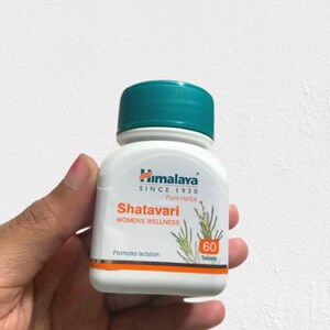 May include: A white bottle of Himalaya Shatavari Women's Wellness tablets with a teal cap. The label includes text and illustrations of plants. The bottle contains 60 tablets and promotes lactation.
