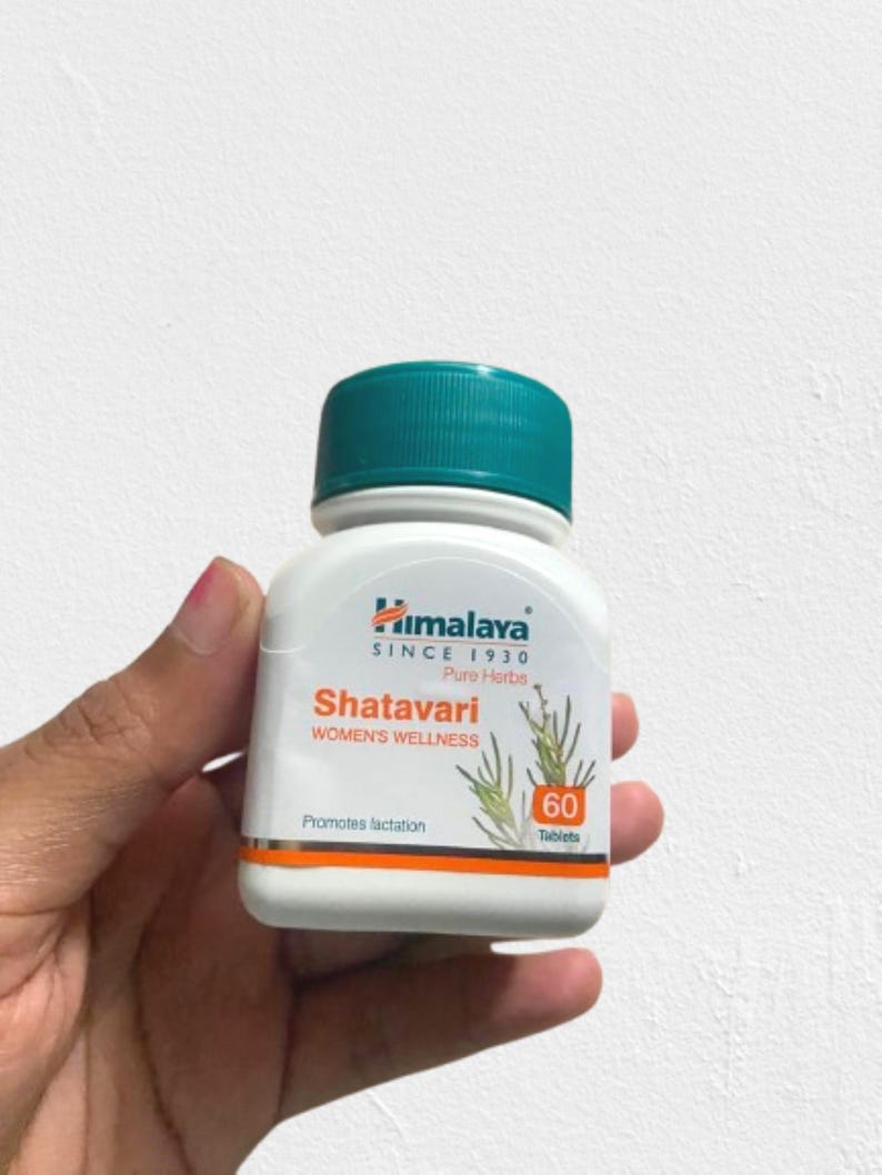 May include: A white bottle of Himalaya Shatavari Women's Wellness tablets with a teal cap. The label includes text and illustrations of plants. The bottle contains 60 tablets and promotes lactation.