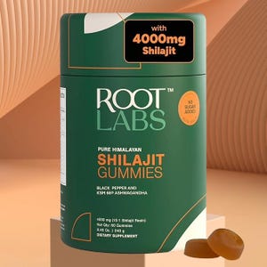 May include: A green cylindrical container of Root Labs Shilajit Gummies. The label includes the text "Pure Himalayan Shilajit Gummies" and "4000mg Shilajit." Two brown gummies are in the foreground. The container also states "No Sugar Added."