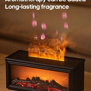 Peut inclure: Une cheminée électrique noire avec un effet de flamme réaliste. La cheminée a un design rectangulaire avec une façade en verre, et le texte "Aromathérapie peut être ajoutée, Parfum longue durée" est visible.