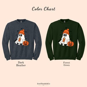 May include: Dark heather and forest green sweatshirts with a Halloween-themed ghost graphic. The ghost wears an orange beanie and holds a pumpkin spice latte, with a jack-o'-lantern and bats. The text "Color Chart" is at the top.