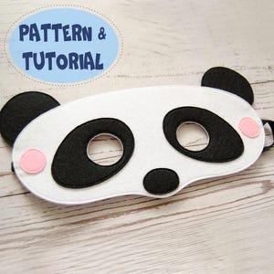 May include: A white felt panda eye mask with black eye and nose details, pink cheek accents, and black ear accents. The mask has a black elastic strap. Text in a blue oval reads "PATTERN & TUTORIAL".