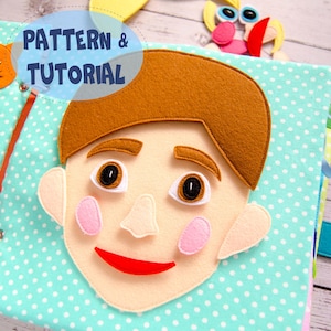May include: A handmade felt quiet book page featuring a boy's face with brown hair, eyebrows, and eyes. The face has pink cheeks and a red smile. The background is light blue with white polka dots. Text on the image reads "PATTERN & TUTORIAL".