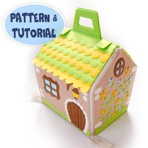 May include: A house-shaped felt carrying case with a green handle and zip closure. The roof is layered with green and yellow scalloped felt. The house features a brown door, windows, and floral accents. Text on the image reads "PATTERN & TUTORIAL".