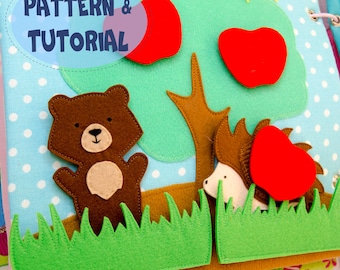 May include: A handmade felt quiet book page featuring a brown bear, hedgehog, tree, and red apples. The background is light blue with white polka dots. The text "PATTERN & TUTORIAL" is in a blue oval.