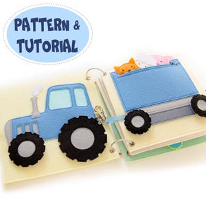 Puede incluir: Un libro tranquilo de fieltro hecho a mano con un tractor azul y un camión azul que transporta figuras de animales. El libro está abierto, mostrando páginas con formas de fieltro cosidas y el texto "PATTERN & TUTORIAL" en un óvalo azul.