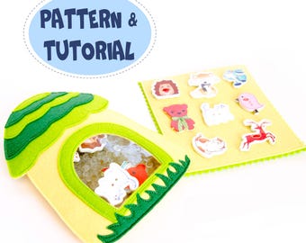 May include: A yellow felt house with a clear window filled with small objects and animal shapes. A separate yellow felt square displays various animal-shaped felt cutouts. The text "PATTERN & TUTORIAL" is in a blue oval.