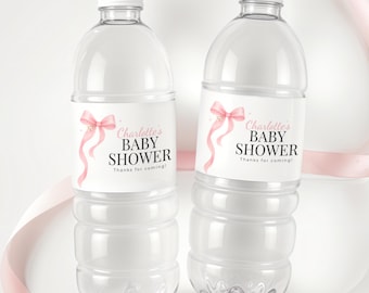 May include: Two clear plastic water bottles with white caps and labels. The labels read "Charlotte's BABY SHOWER" with a pink bow and ribbon design. The text "Thanks for coming!" is also on the label.