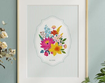 May include: A framed wall art print featuring a central illustration of a colorful floral bouquet with pink, yellow, and blue flowers inside a decorative scalloped border. The background has vertical gray stripes and the text Est 2008 at the bottom.
