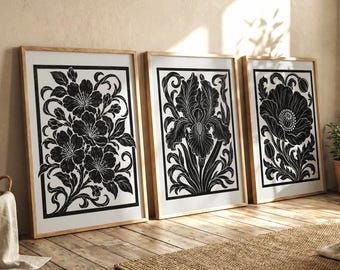 May include: Three rectangular framed wall art pieces featuring black and white botanical illustrations. Each frame contains a distinct floral design, including cherry blossoms, an iris, and a poppy, all rendered in high-contrast black ink.