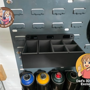 May include: A black storage unit with four compartments, attached to a grey pegboard. Below, several spray paint cans with blue, yellow, red, and green lids are visible. The image includes the text "Dad's 3D World Exclusive".