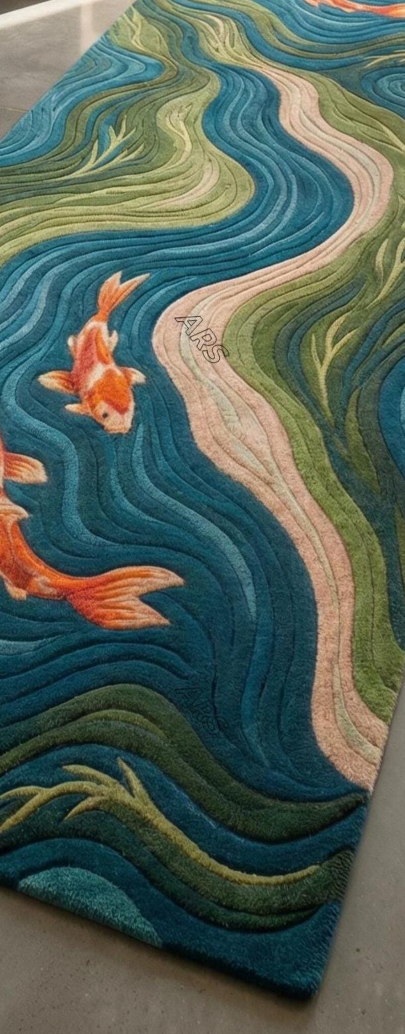 May include: A rectangular rug with a koi fish design. The rug features a blue, green, and beige color palette, with orange koi fish swimming in a stylized river. The rug has a textured appearance.