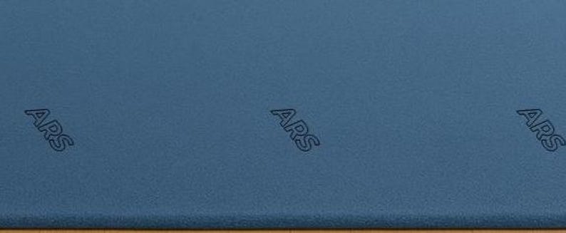 May include: A textured, blue surface with the letters "ARS" embossed in three places. The surface has a matte finish and appears to be made of a durable material. The letters are in a sans-serif font.