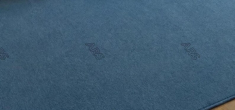 May include: Close-up of a textured, blue fabric with the letters "ARS" subtly embroidered across the surface. The fabric has a soft, matte appearance and a consistent color throughout.