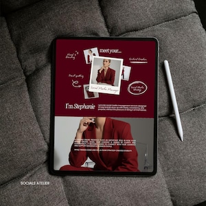 May include: A digital tablet displaying a maroon-colored graphic with the text "meet your..." and "Social Media Manager." A white stylus rests on the side. The tablet is on a gray, textured surface.