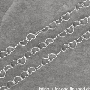 May include: Three silver heart-shaped chains on a gray background. Listing is for one finished chain. Enlarged to show detail.