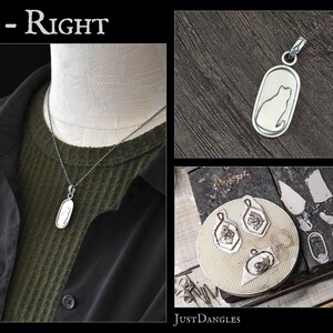 May include: Silver cat pendant necklace with a detailed cat silhouette inside an oval frame. The image also shows other pendant designs and the text "Sit - Right" and "JustDangles".