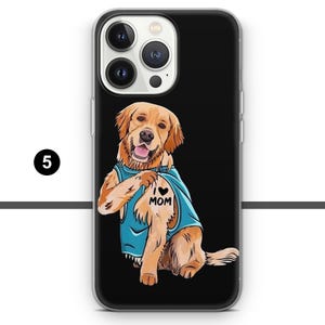 May include: Black phone case featuring a cartoon Golden Retriever wearing a blue shirt with "I ❤️ MOM" tattoo. The dog is smiling with its tongue out. The case has a clear border and a black background.