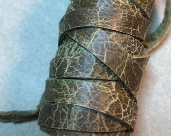 May include: A roll of brown leather cord with a cracked texture.