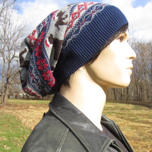 May include: A blue and grey knitted beanie with a geometric pattern. The beanie is slouchy and has a fold-over brim.