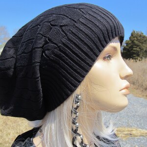 Puede incluir: Un gorro negro de punto con un patr&oacute;n de trenza. El gorro est&aacute; hecho de un material suave y c&aacute;lido, perfecto para mantener la cabeza caliente en invierno.