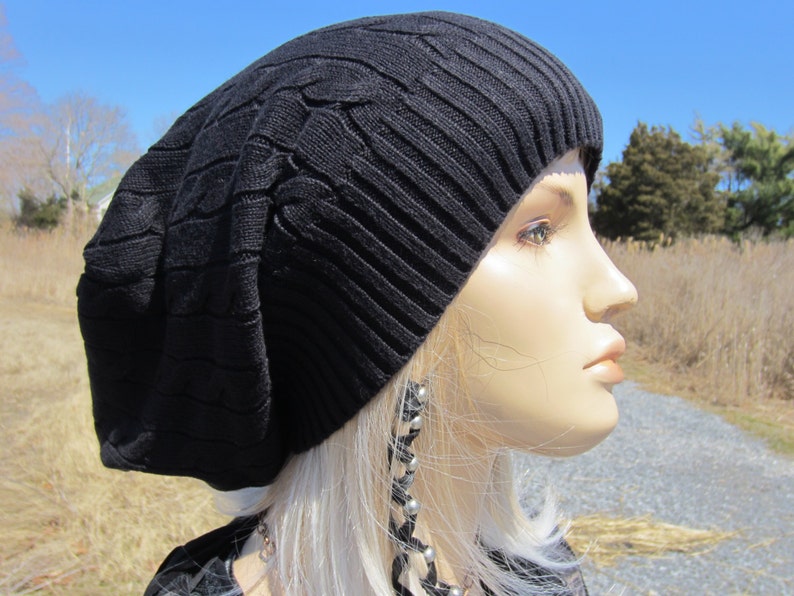 Puede incluir: Un gorro negro de punto con un patr&oacute;n de trenza. El gorro est&aacute; hecho de un material suave y c&aacute;lido, perfecto para mantener la cabeza caliente en invierno.
