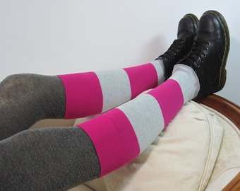 May include: A pair of grey and pink striped knee-high socks with black leather boots.