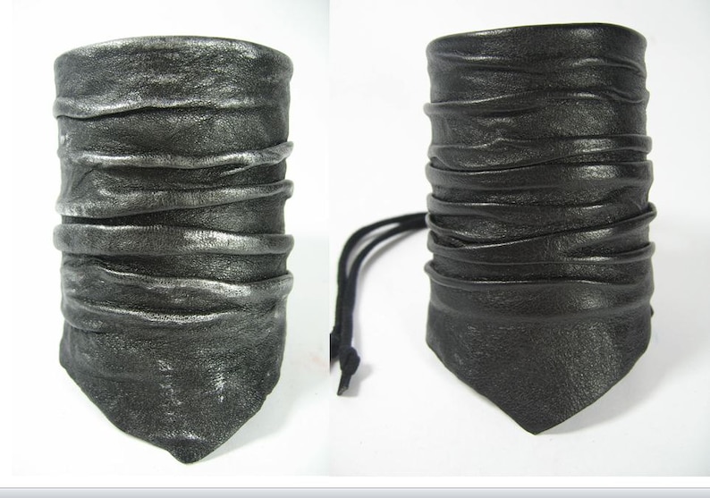 May include: Two leather bracelets with a layered, pleated design. One bracelet is black and the other is silver.