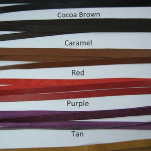 May include: Close-up of leather strips in various colors: black, cocoa brown, caramel, red, purple, and tan. Each strip is labeled with its color name. The strips are thin and appear to be made of genuine leather.