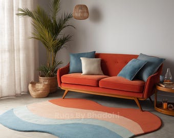 Könnte beinhalten: Ein Wohnzimmer mit einem orangefarbenen Sofa und blauen Kissen. Ein farbenfroher, wellenförmiger Teppich in Blau-, Pfirsich- und Orangetönen liegt auf dem Boden. Eine Topfpflanze und ein Weidenkorb ergänzen den Raum.