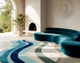 May include: A modern living room featuring a teal curved sofa and a colorful rug. The rug has a wavy design with shades of blue, green, and white. A fireplace and large window are also visible.