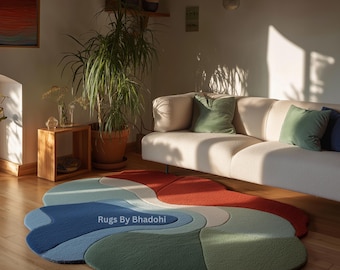 Puede incluir: Una alfombra abstracta con forma orgánica y colores vibrantes. Presenta secciones azules, verdes y rojas, creando un diseño moderno y artístico. El texto "Rugs By Bhadohi" es visible en la alfombra.