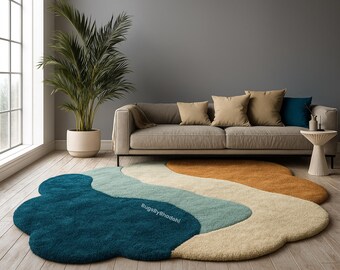 Puede incluir: Una alfombra abstracta con un diseño en forma de nube en tonos turquesa, azul claro, beige y naranja. La alfombra está colocada sobre un suelo de madera frente a un sofá gris y una ventana grande. El diseño recuerda a un paisaje fluido.