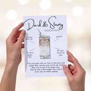 Könnte beinhalten: Eine Rezeptkarte für einen Dark & Stormy Cocktail, gehalten von Händen. Die Karte zeigt eine Illustration des Getränks, der Zutaten und der Anweisungen. Das Rezept enthält braunen Rum, Ginger Beer und Limettensaft.