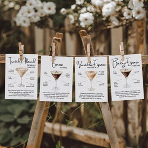 May include: Four cocktail recipe cards for Espresso Martinis are displayed on a wooden stand. Each card, held by a clothespin, features a different recipe: Toasted Almond, Espresso, Vanilla Espresso, and Bailey's Espresso. The recipes include ingredients and instructions.