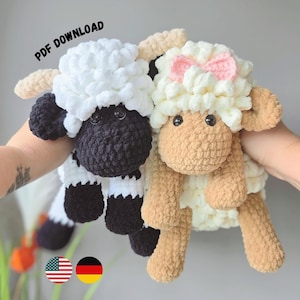 Könnte beinhalten: Zwei Plüschschafe aus dicker Wolle. Ein Schaf hat ein schwarzes Gesicht und schwarze Beine mit weißer Wolle, das andere hat ein beiges Gesicht und Beine mit weißer Wolle und einer kleinen rosa Schleife. Der Text PDF DOWNLOAD ist oben zu sehen.