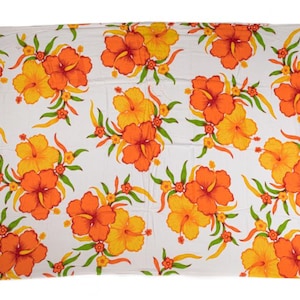 Könnte beinhalten: Weißes rechteckiges Strandtuch mit einem sich wiederholenden Muster aus orangefarbenen und gelben Hibiskusblüten und grünen Blättern. Das Handtuch hat Fransen.