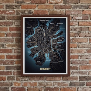 Op de afbeelding: Ingelijste kaart van Gotham City, met een gedetailleerde illustratie van de indeling van de stad met straten, waterwegen en bezienswaardigheden. De kaart heeft een teal achtergrond, een donkerbruine lijst en de woorden "Gotham City" onderaan.