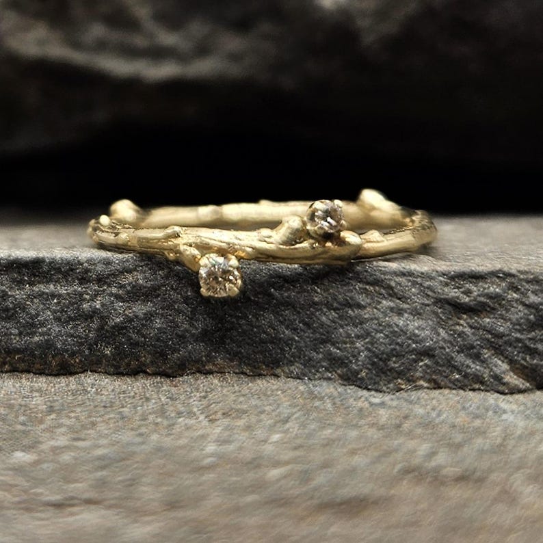 Delicate 14K soliid yellow gold ring cast from a fallen twig. Two prong set champagne diamonds (1.5mm and 2mm)nestled into the tiny buds of the twig.