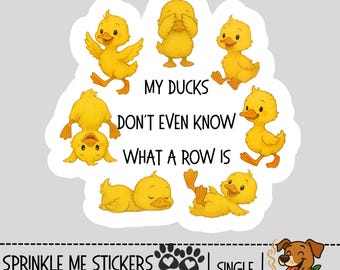 May include: A die-cut sticker featuring a circle of cartoon yellow ducklings in various poses. The text "MY DUCKS DON'T EVEN KNOW WHAT A ROW IS" is centered. The sticker also includes the seller's name and website.